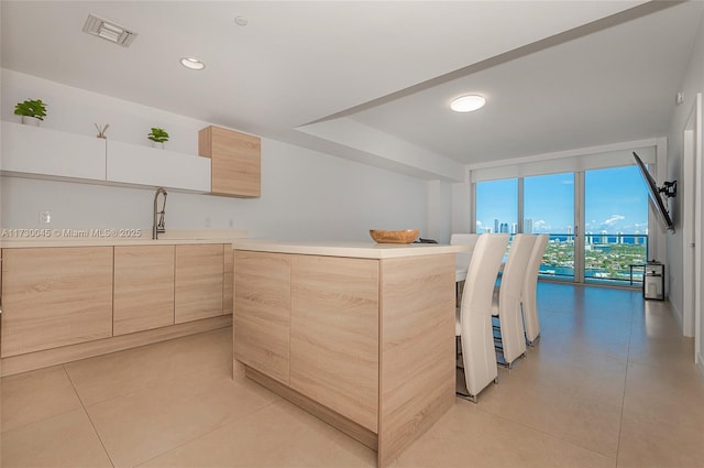 kitchen featuring modern cabinets, visible vents, a sink, and light brown cabinetry