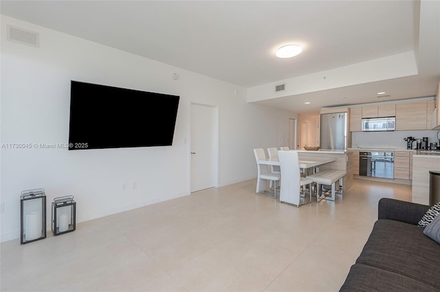 living room featuring recessed lighting, visible vents, and baseboards