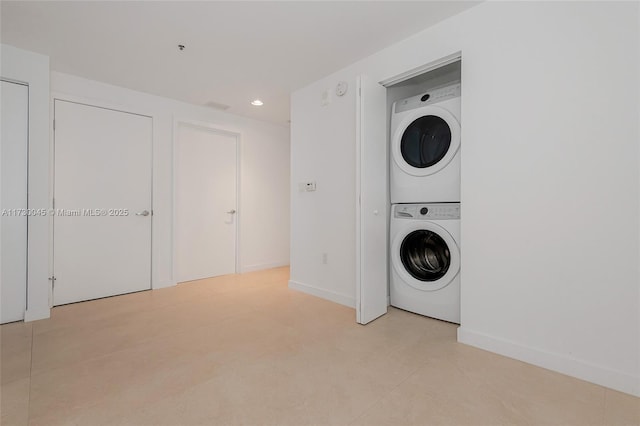 washroom featuring laundry area, stacked washer / dryer, recessed lighting, and baseboards