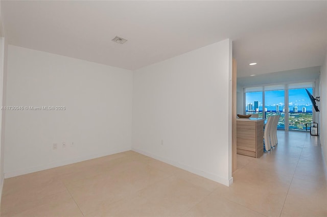 empty room with recessed lighting, visible vents, and baseboards