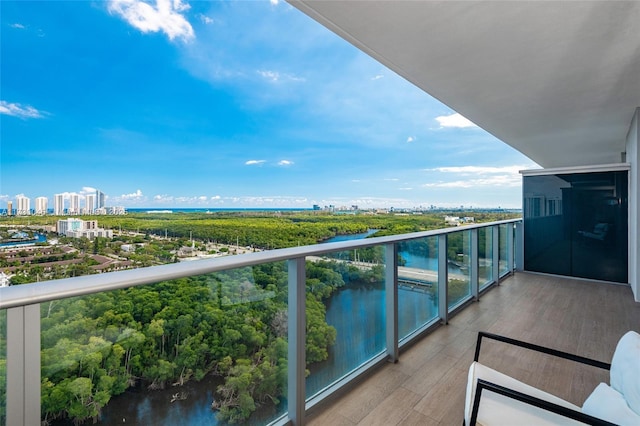 balcony featuring a water view and a city view