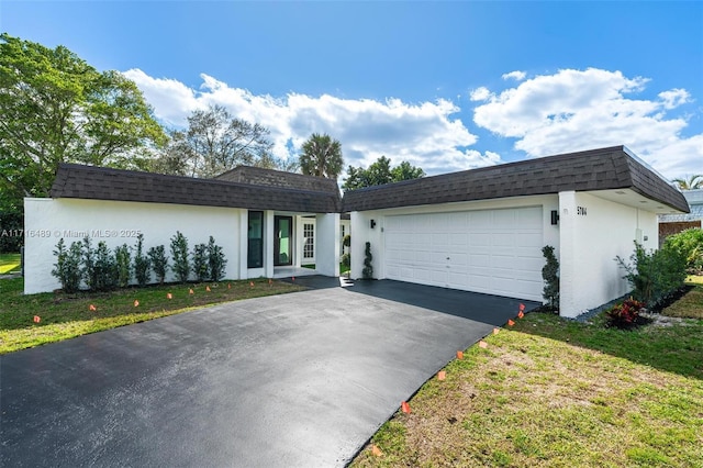 ranch-style home featuring a garage and a front lawn