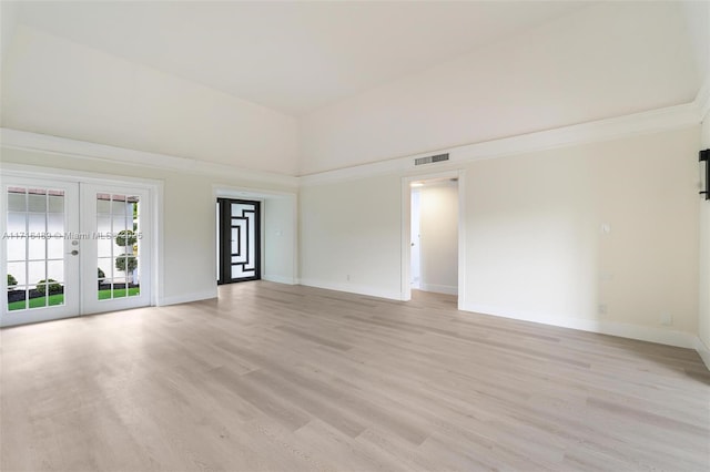 empty room with french doors, light wood-type flooring, visible vents, and baseboards