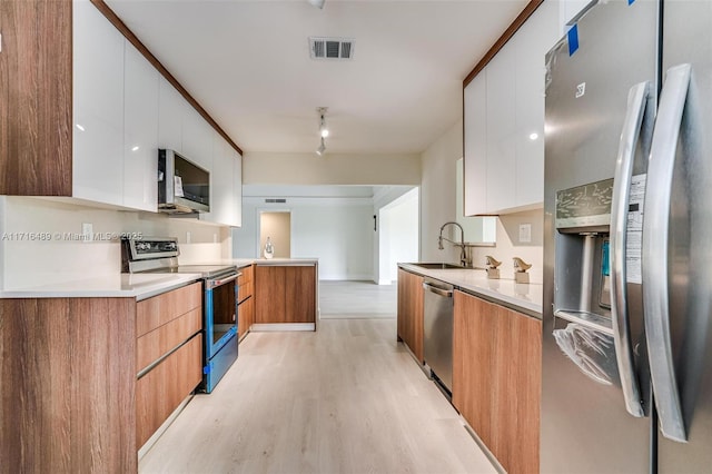 kitchen featuring visible vents, modern cabinets, appliances with stainless steel finishes, light countertops, and white cabinetry