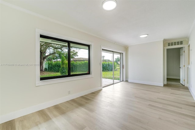 unfurnished room with light wood finished floors, baseboards, visible vents, and ornamental molding