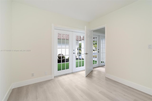 unfurnished room featuring baseboards, french doors, and light wood-style floors