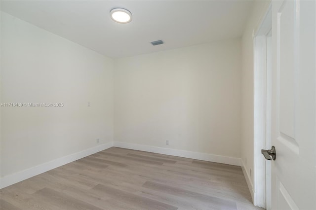 spare room with light wood-style floors, visible vents, and baseboards