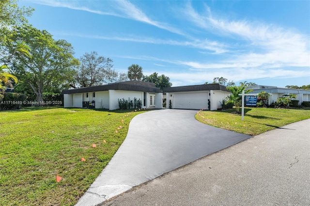 single story home with a garage, driveway, and a front lawn