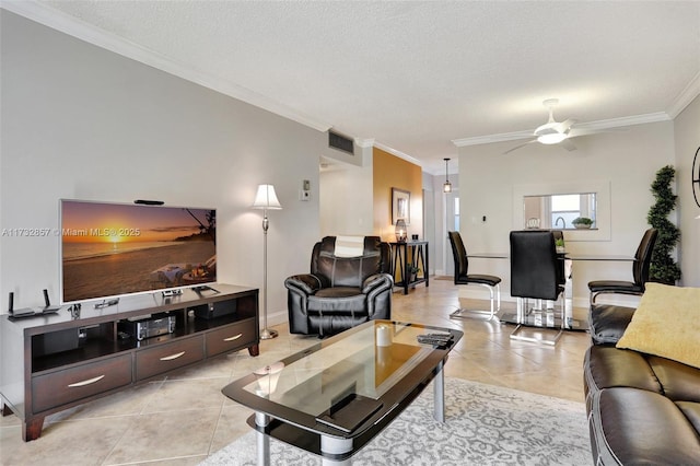 tiled living room with ceiling fan, crown molding, and a textured ceiling