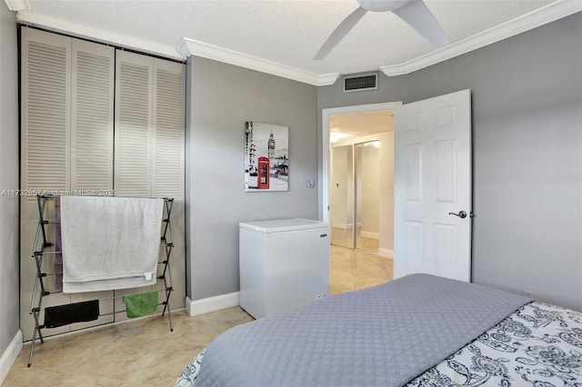 bedroom with ornamental molding, fridge, light tile patterned floors, ceiling fan, and a textured ceiling