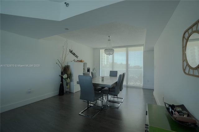 dining area featuring a notable chandelier, dark hardwood / wood-style flooring, and a wall of windows