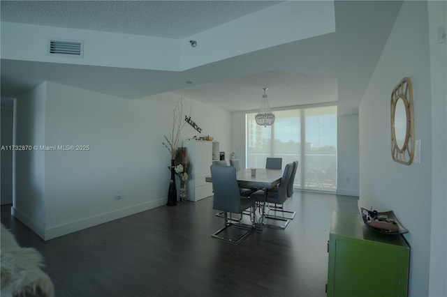 dining space with dark hardwood / wood-style floors and a textured ceiling