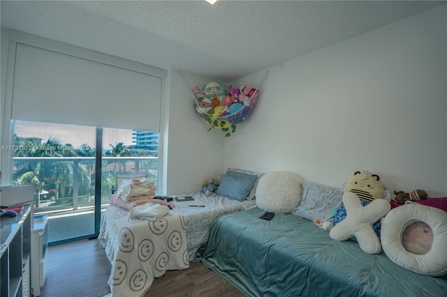 bedroom with dark hardwood / wood-style flooring and a textured ceiling