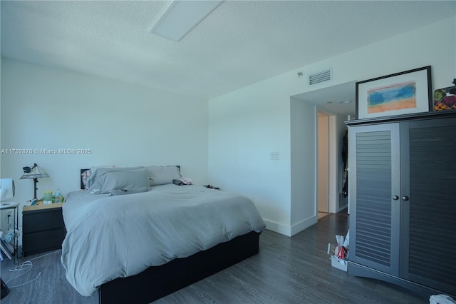 bedroom with dark wood-type flooring and a textured ceiling