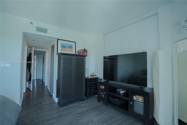 living room featuring dark hardwood / wood-style floors and a textured ceiling