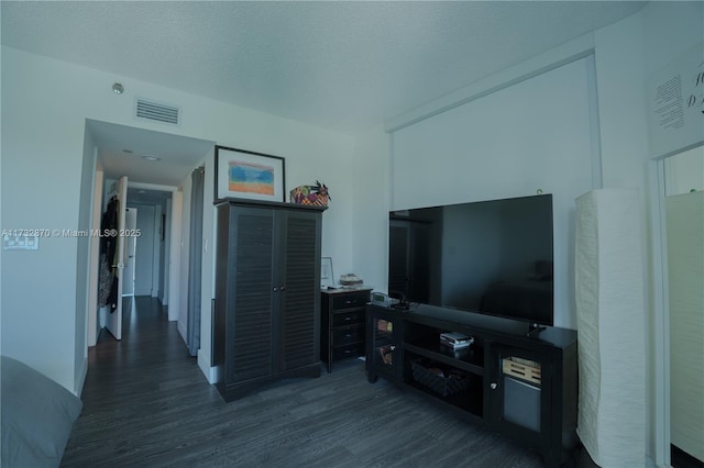 living room with dark hardwood / wood-style floors and a textured ceiling