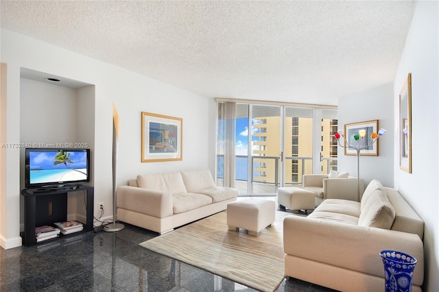 living room featuring expansive windows and a textured ceiling