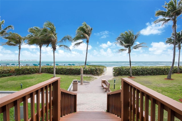 view of community with a view of the beach, a water view, and a lawn