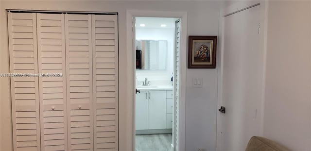 hallway with hardwood / wood-style flooring and sink