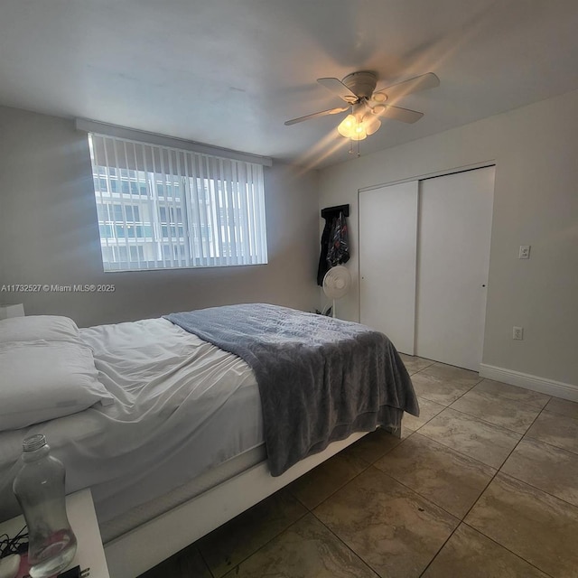 tiled bedroom with ceiling fan and a closet