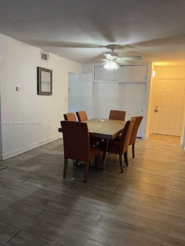 dining room with hardwood / wood-style flooring, ceiling fan, and a textured ceiling