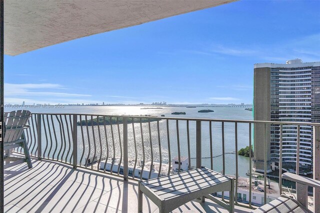 balcony featuring a water view and a beach view