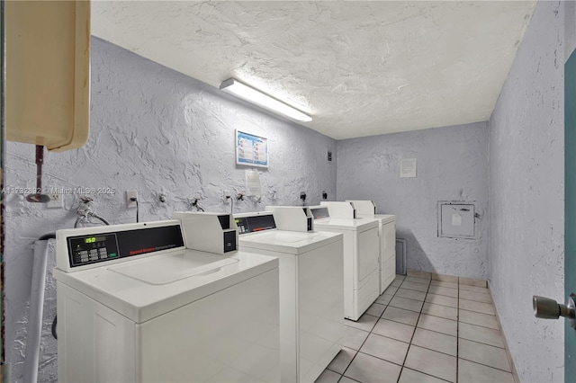 clothes washing area with light tile patterned flooring and washer and dryer