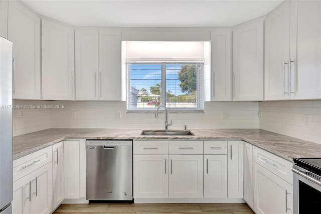 kitchen featuring sink, light stone counters, dishwasher, decorative backsplash, and white cabinets