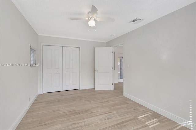 unfurnished bedroom with light hardwood / wood-style flooring, ceiling fan, and a closet