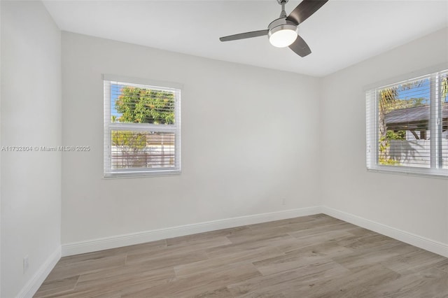 empty room with ceiling fan and light hardwood / wood-style flooring