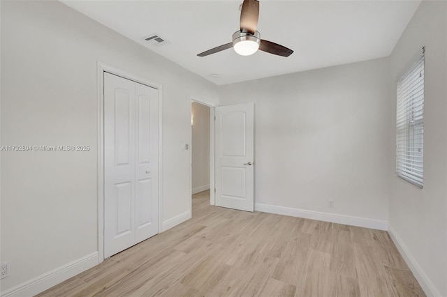 unfurnished bedroom with a closet, ceiling fan, and light wood-type flooring