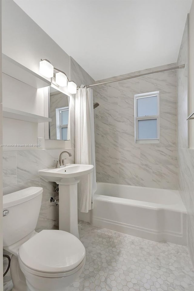 full bathroom with tile patterned flooring, tile walls, shower / tub combo, and toilet