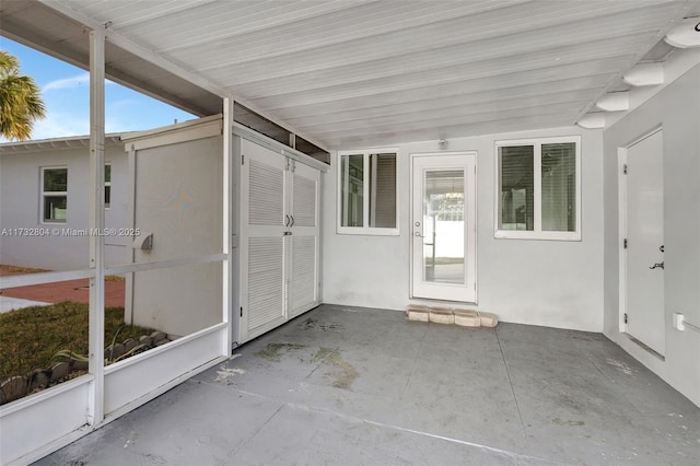 unfurnished sunroom with lofted ceiling with beams