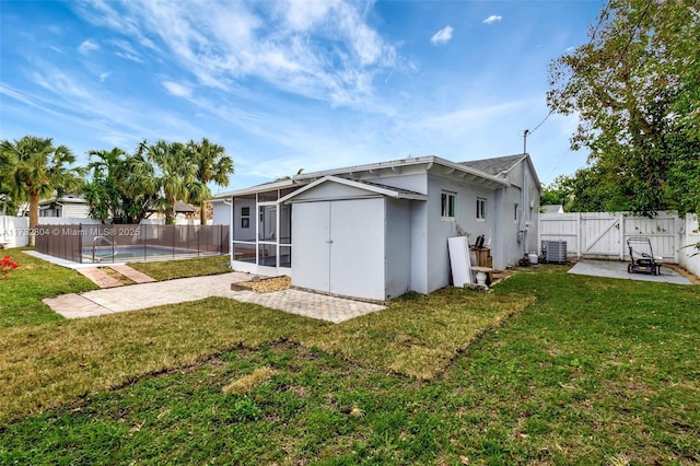 rear view of house featuring a yard, a fenced in pool, a patio, and central air condition unit