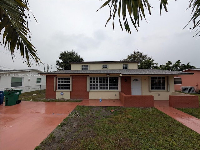 view of front of home featuring central AC unit and a front lawn