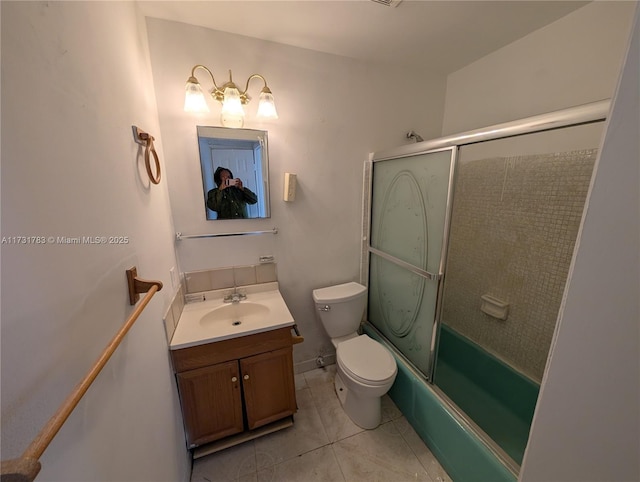 full bathroom featuring vanity, combined bath / shower with glass door, tile patterned floors, and toilet