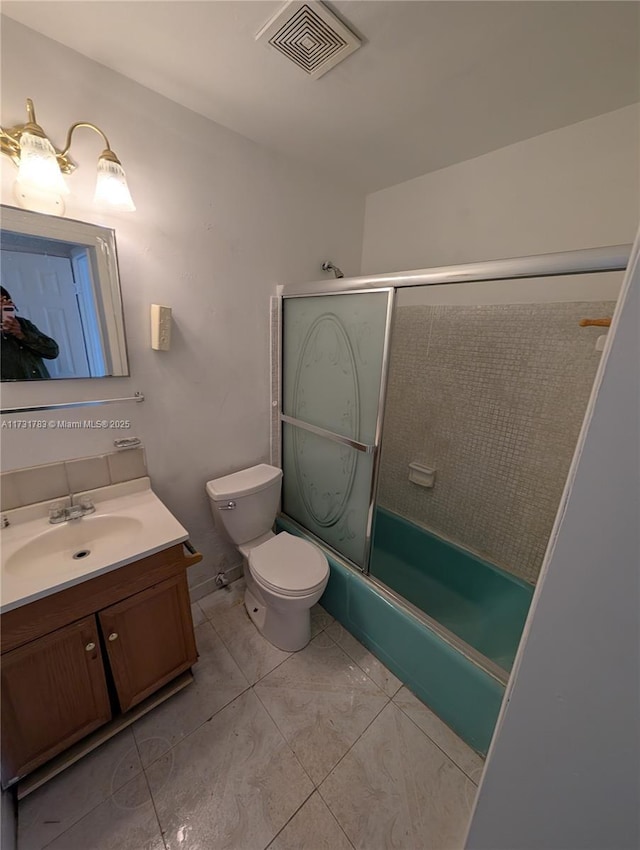 full bathroom featuring vanity, tile patterned floors, enclosed tub / shower combo, and toilet