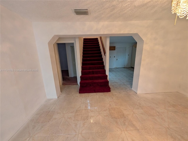 stairway with a textured ceiling