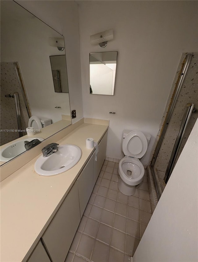 bathroom featuring vanity, tile patterned floors, and toilet