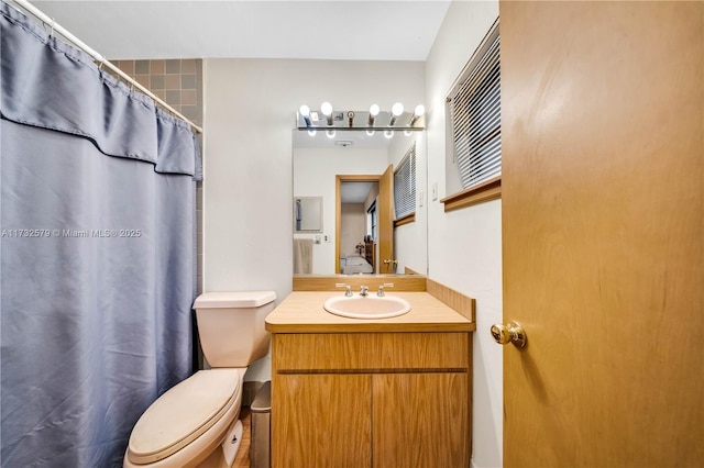 bathroom with vanity, toilet, and curtained shower