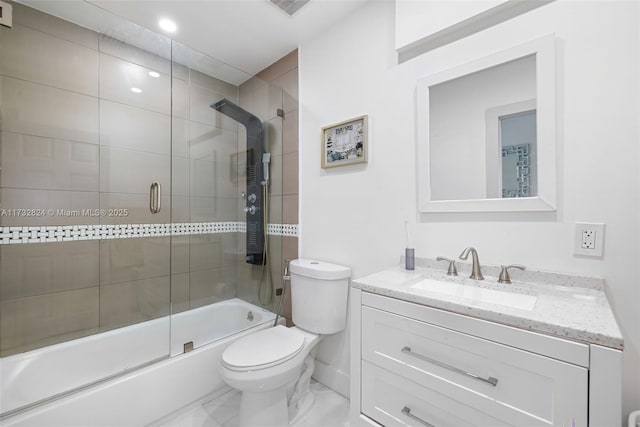 full bathroom with enclosed tub / shower combo, vanity, and toilet