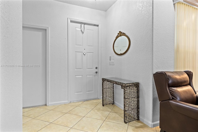 entrance foyer with light tile patterned floors and baseboards