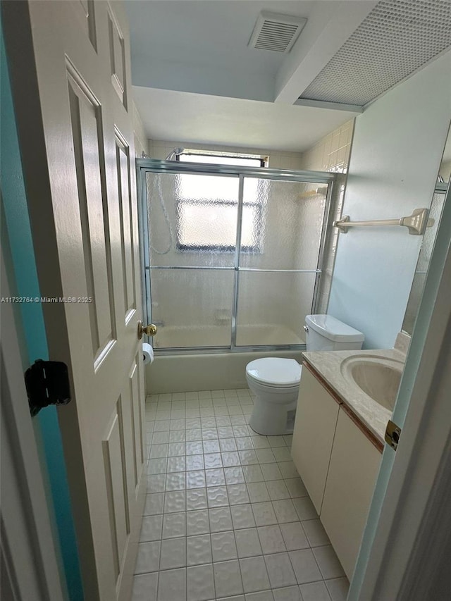 full bathroom featuring vanity, toilet, tile patterned flooring, and combined bath / shower with glass door