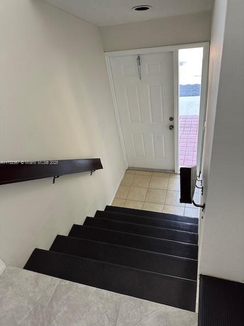 stairs featuring tile patterned floors