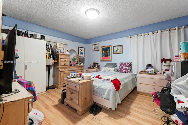 bedroom with light hardwood / wood-style flooring and a textured ceiling