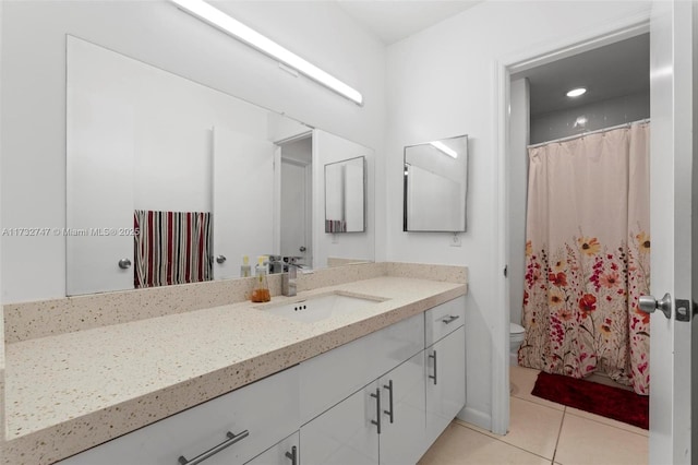 bathroom featuring vanity, tile patterned flooring, and toilet