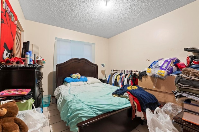 bedroom featuring tile patterned flooring and a textured ceiling