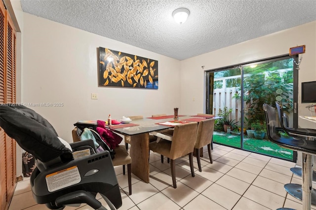 dining area with light tile patterned floors and a textured ceiling