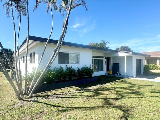 back of property with a garage and a yard