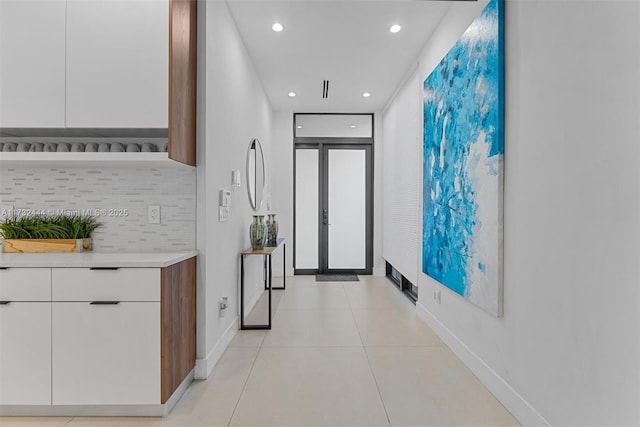 corridor featuring french doors, a wall of windows, and light tile patterned flooring